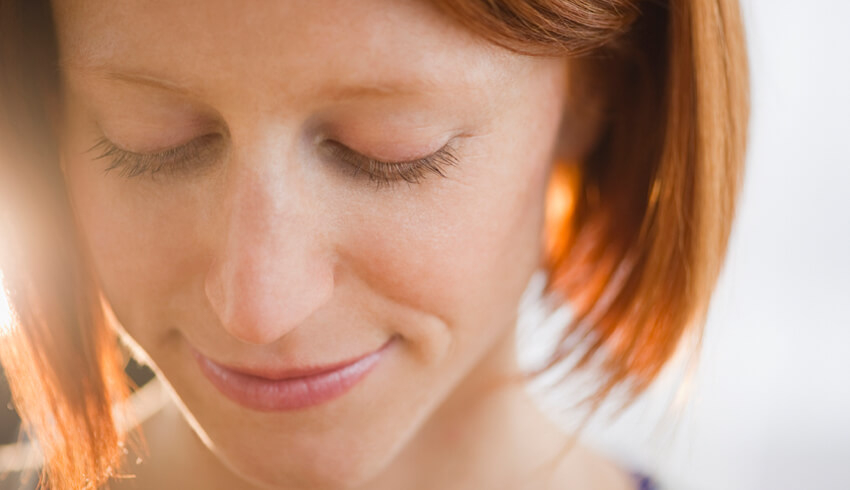 A woman pursing her lips and looking downwards
